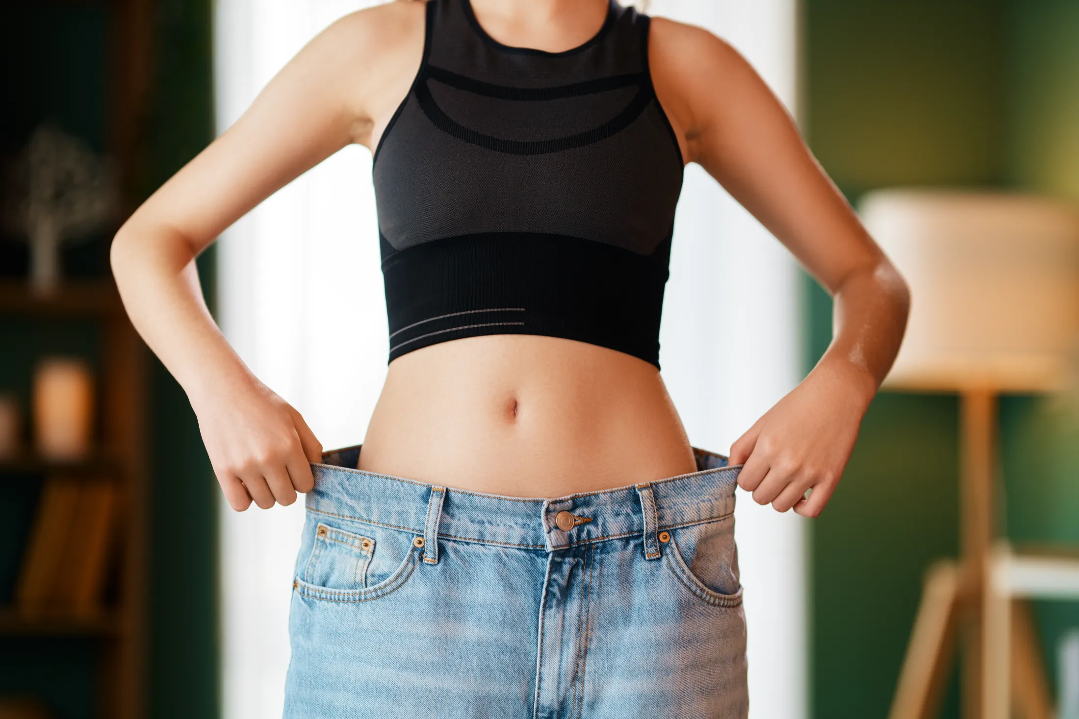 a young woman is trying on big jeans utc