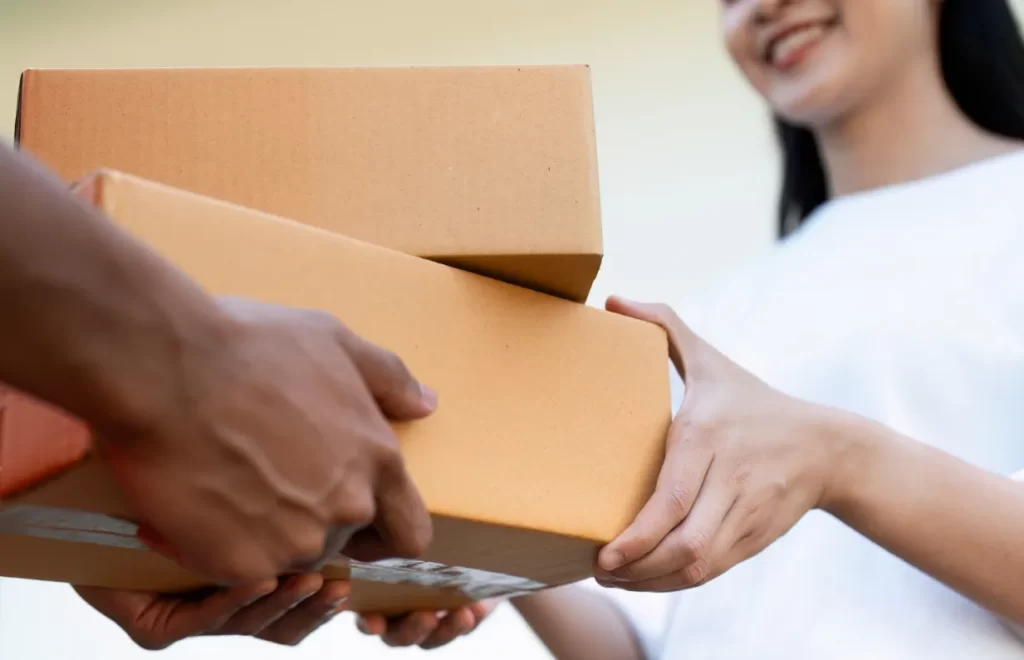 asian young delivery man delivering package to fem utc