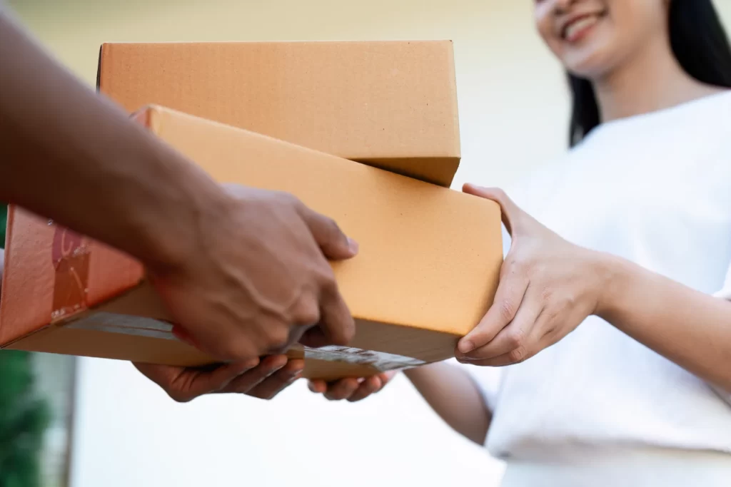 asian young delivery man delivering package to fem utc