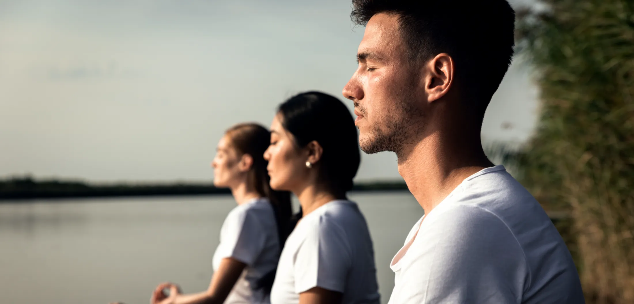 group of people doing yoga exercises by the lake a utc