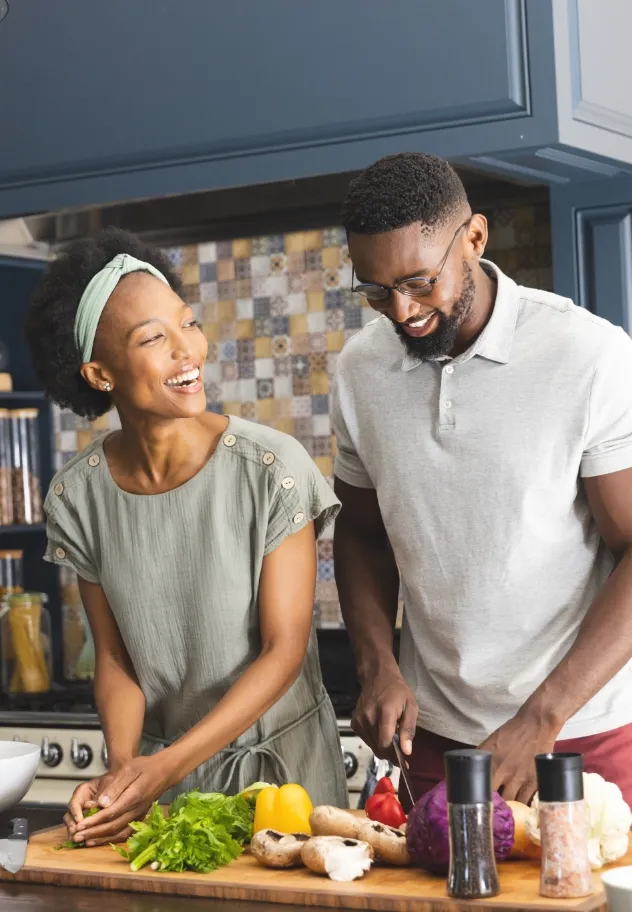 happy african american couple cutting vegetables utc