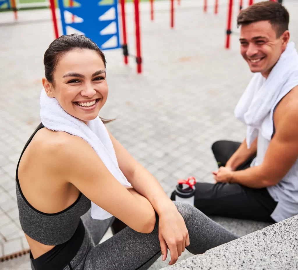 happy young couple relaxing after workout on sport utc