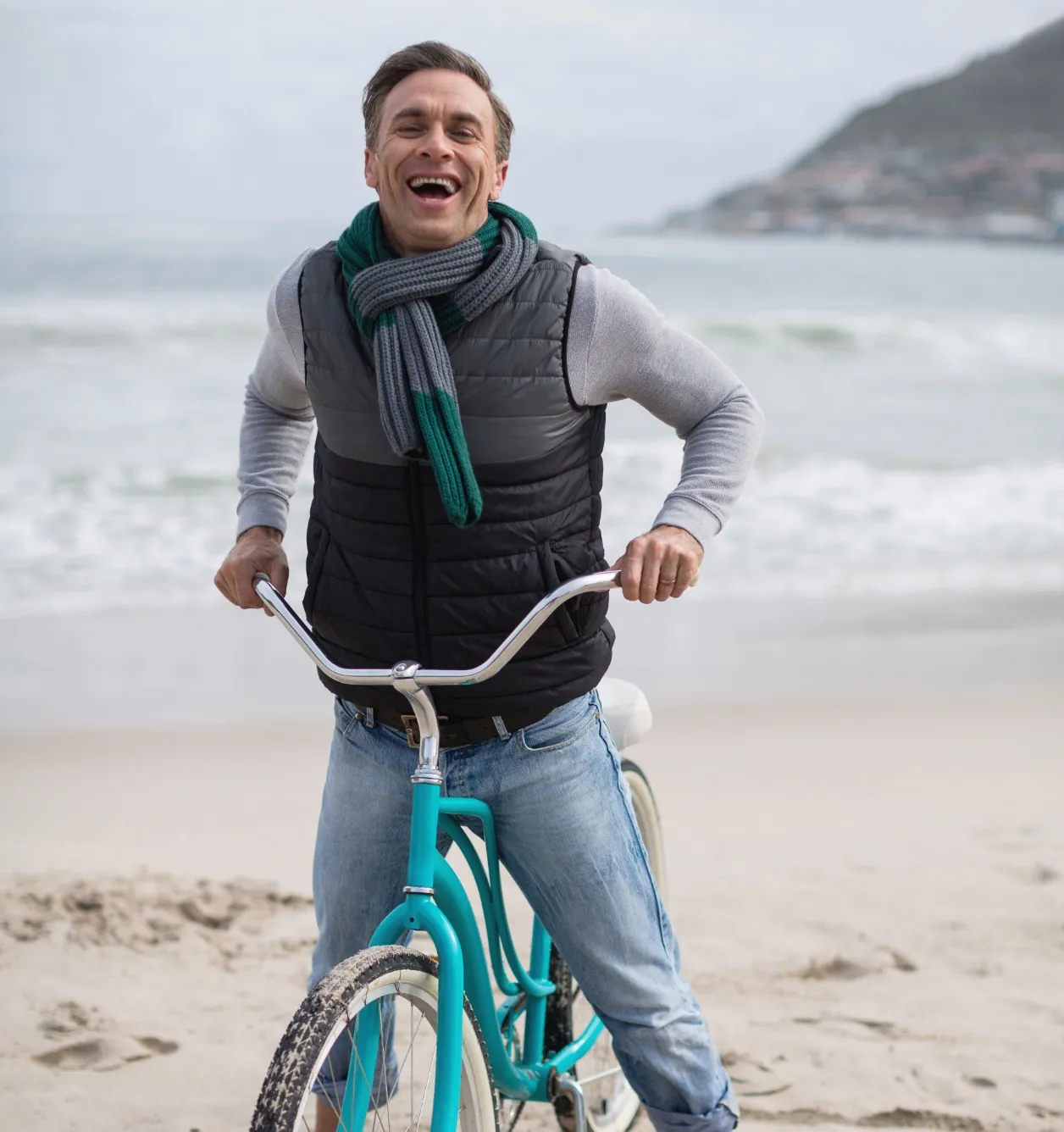 portrait of mature man riding bicycle on the beach utc