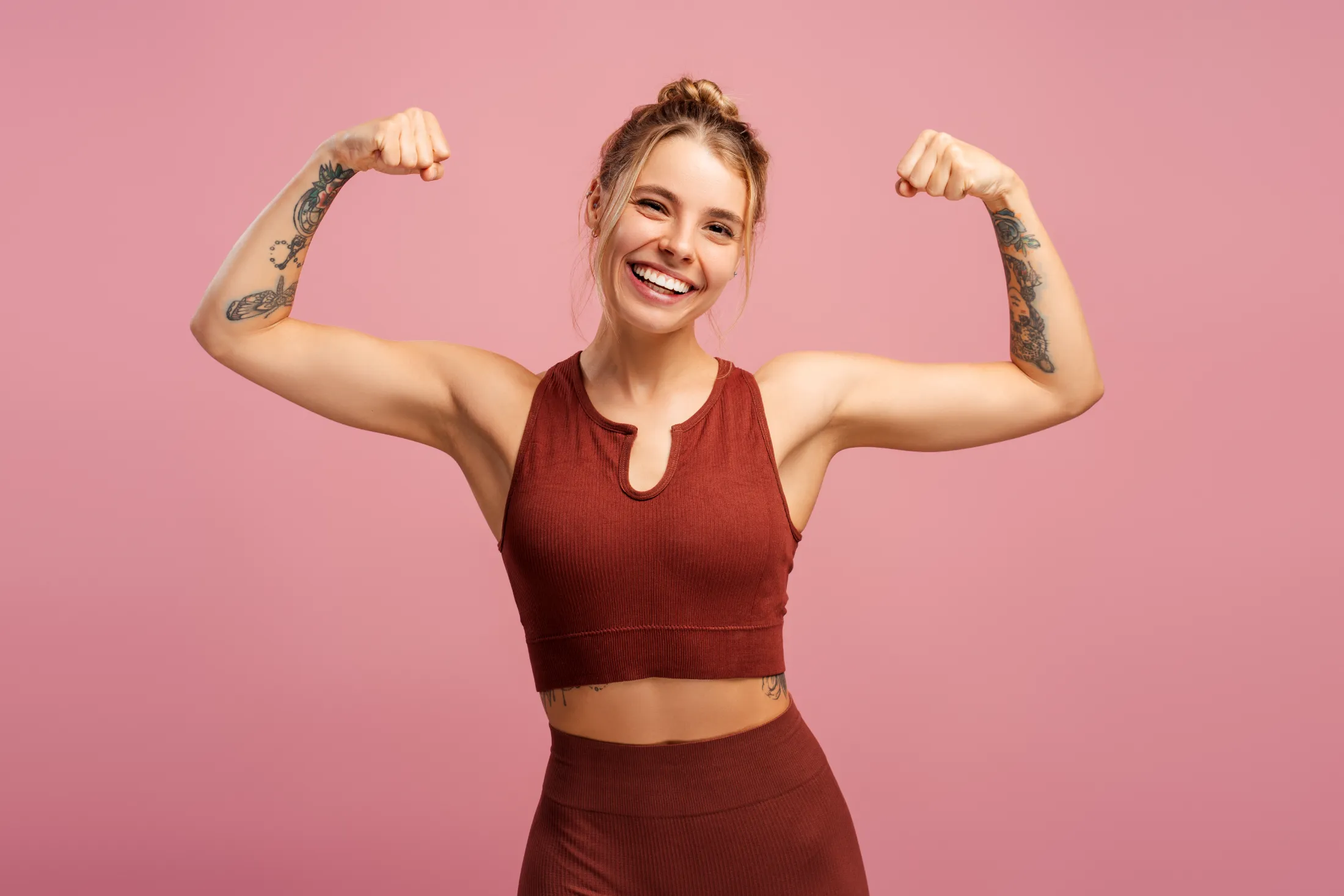 smiling fit woman showing her muscles on hands lo utc