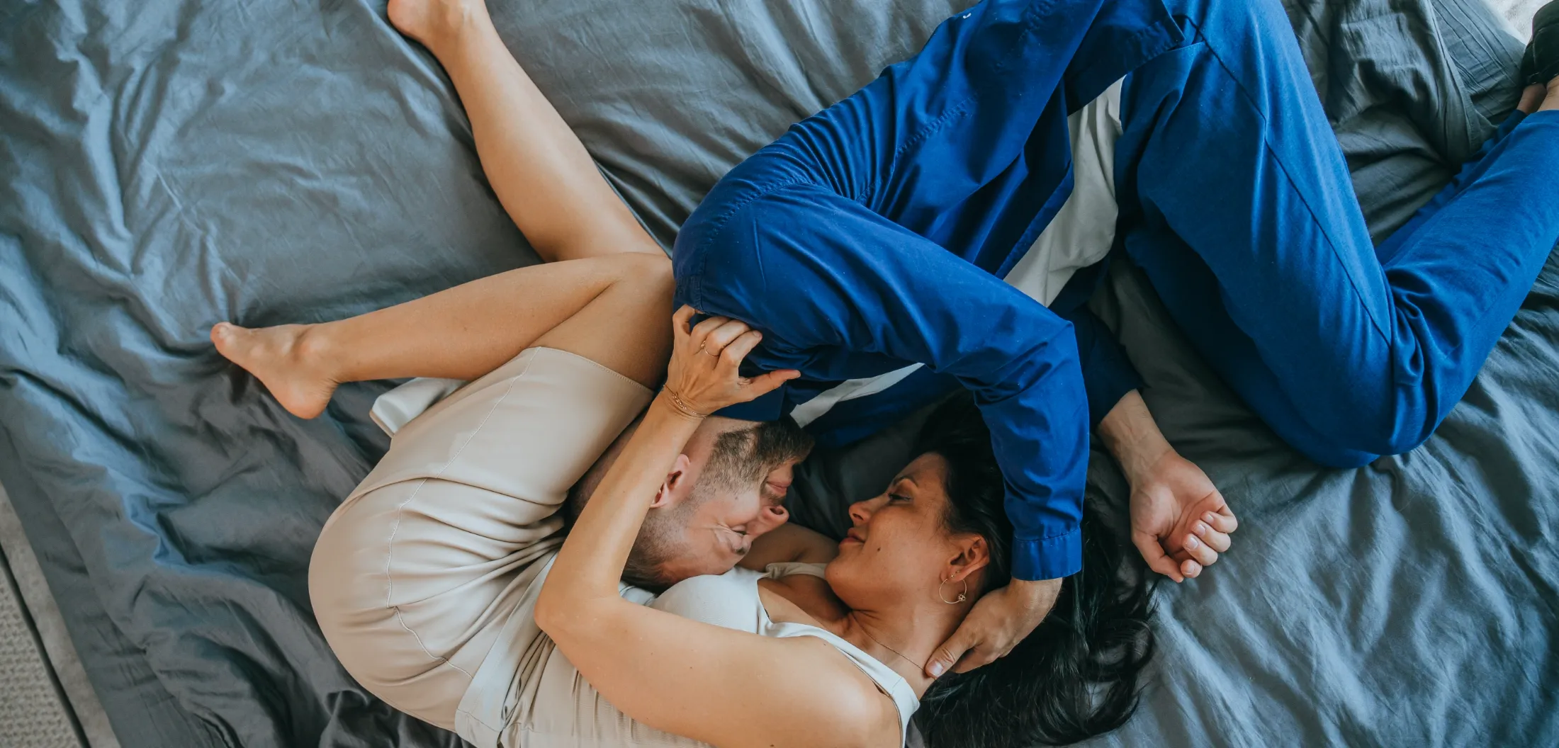 top view on kissing young couple laying on bed hom utc