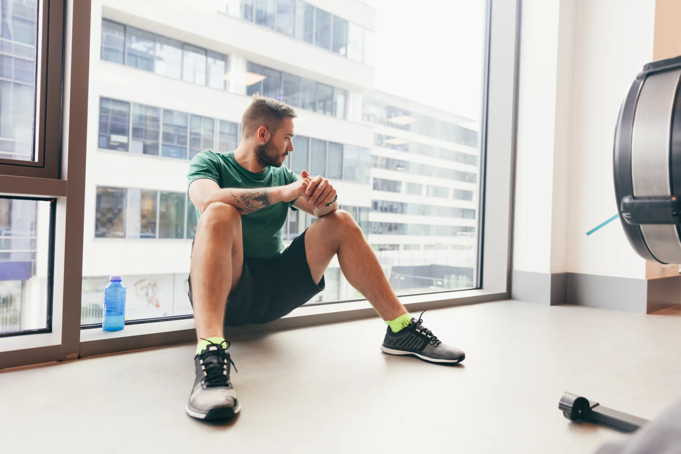 young man having a break in his gym workout utc